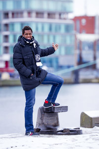 Wael Jallouz vor  maritimer Kulisse am Kieler Hafen. 