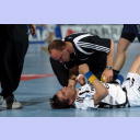 THW-Kapit�n Stefan L�vgren liegt verletzt am Boden, Physiotherapeut Bj�rn Rother kniet bei ihm.