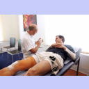 THW-Mannschaftsarzt Dr. Frank Pries erkl�rt Viktor Szilagyi, der auf einer Behandlungsliege liegt, anhand eines Modells die Verletzung im Knie.